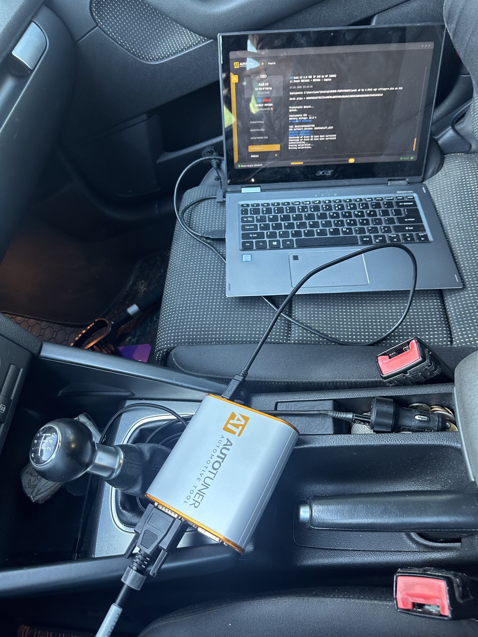 Wnętrze Audi A3 2.0 TDI z podłączonym interfejsem OBD i laptopem uruchomionym do aktualizacji mapy silnika celem wyłączenia układu EGR.
