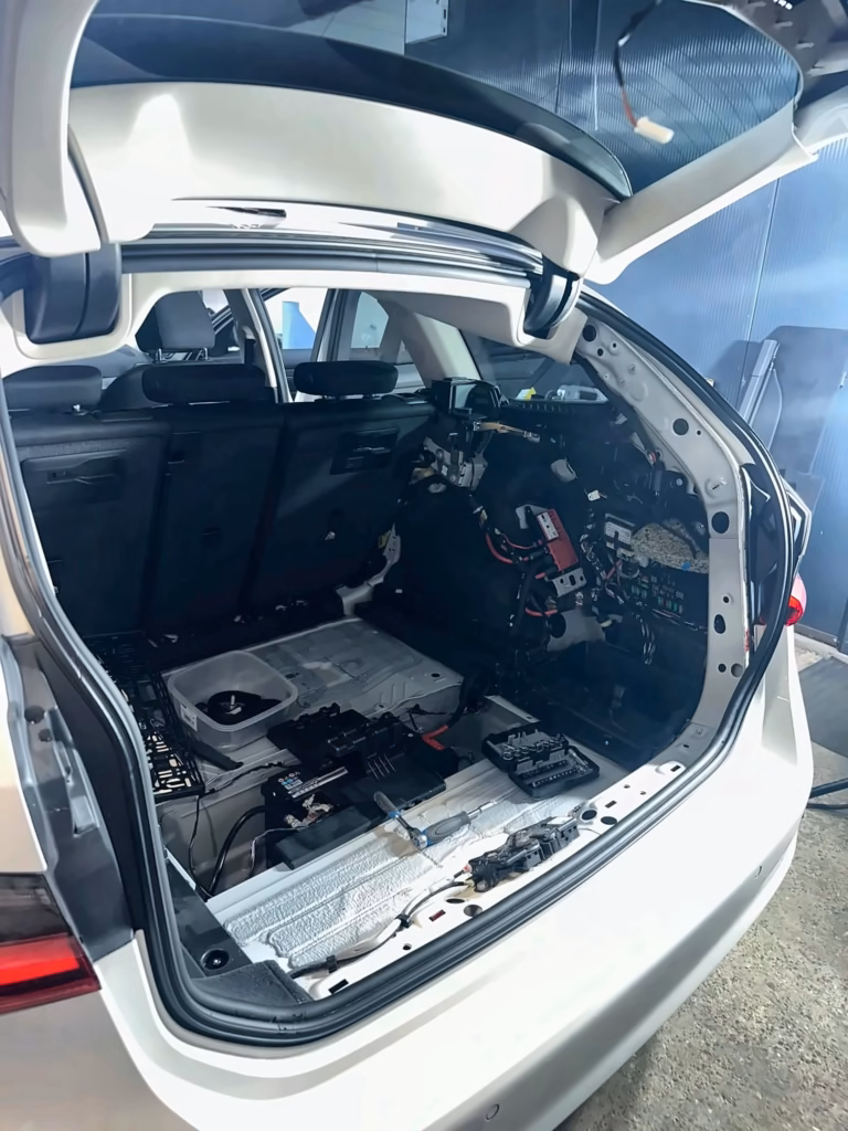 Rozebrany bagażnik BMW G21 podczas montażu kamery cofania