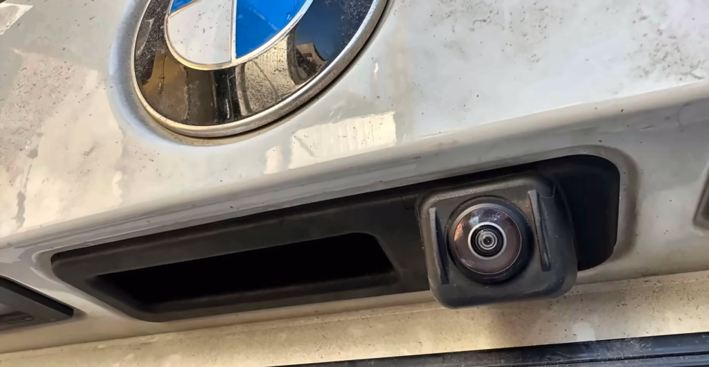 Kamera cofania zamontowana w klapie BMW G21 pod znaczkiem BMW